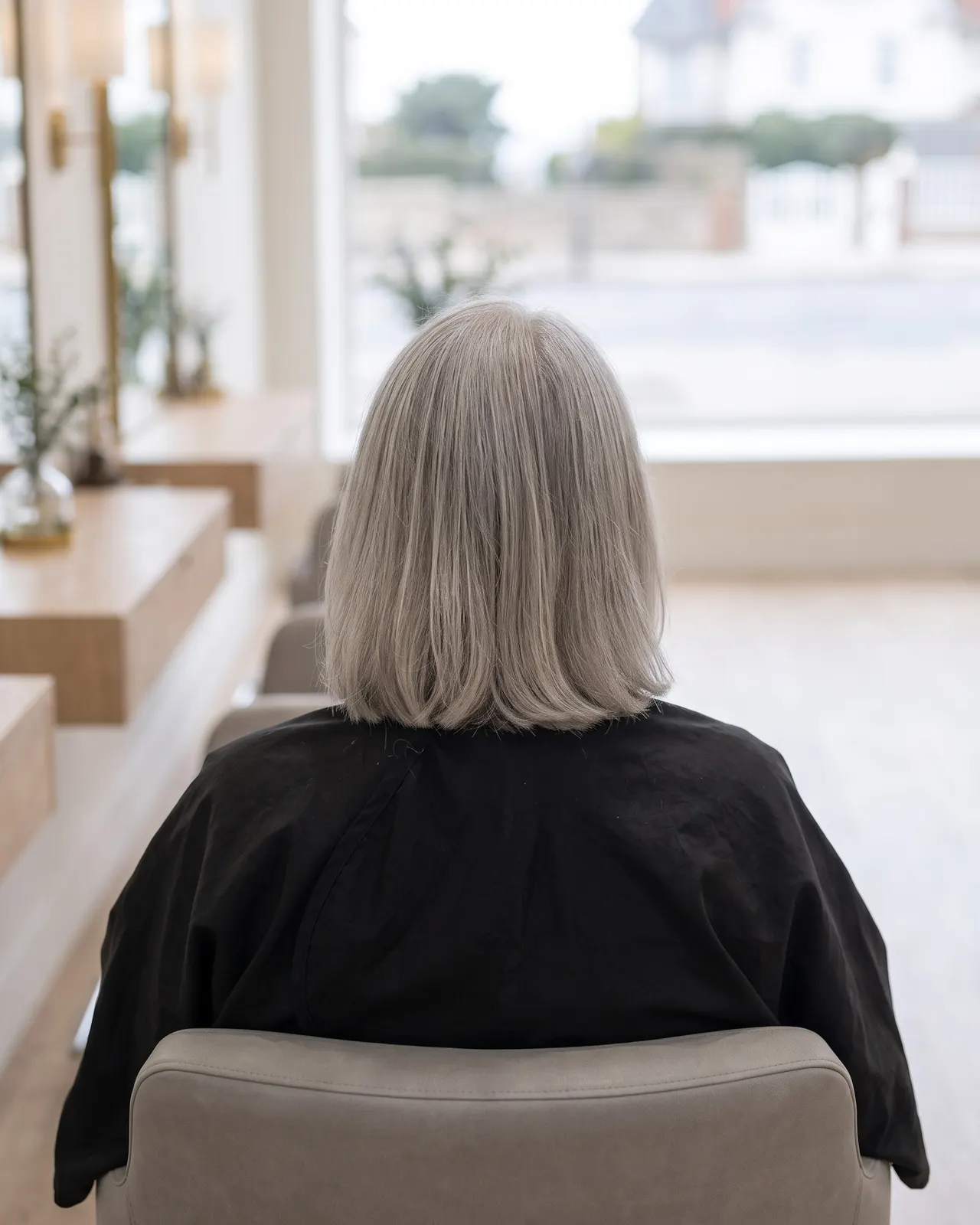 Coupe courte sur cheveux gris naturels, cliente d'une soixantaine d'années de trois quarts
